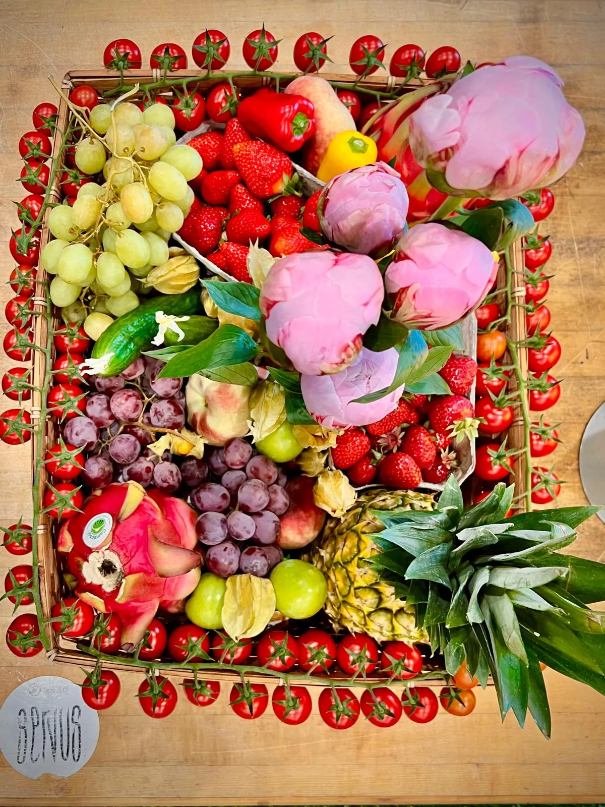 Festlich verpackter Geschenkkorb mit Trauben, Granatapfel und Spezialitäten